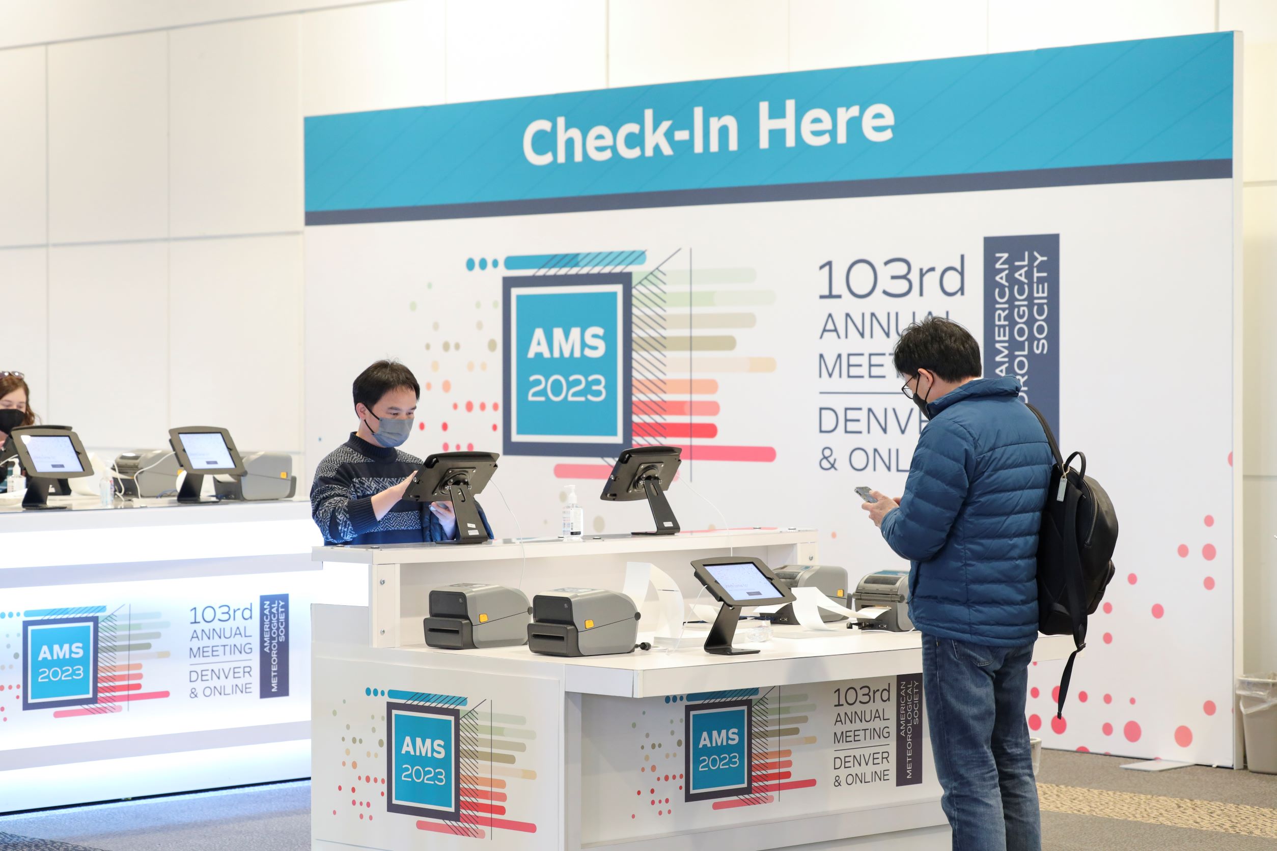 Alt text: Check-in area for the event, featuring a large sign that reads 